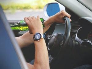 Photo of someone drinking behind the wheel of a car